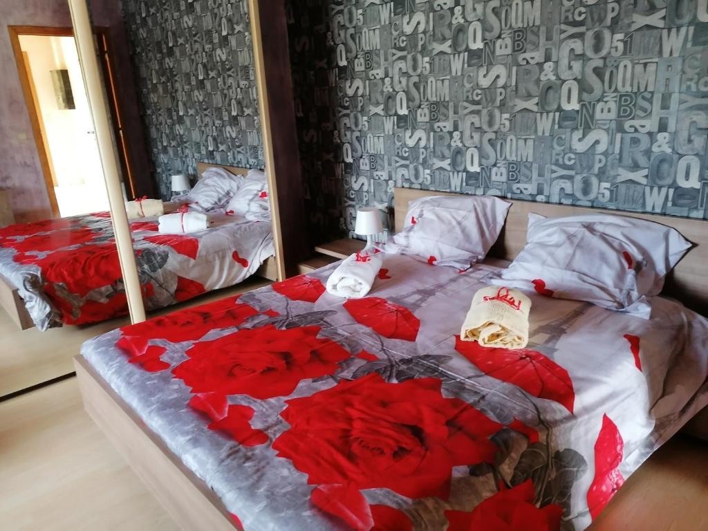 a bedroom with two beds with red roses on them at Sweet Home En Gaume in Chiny