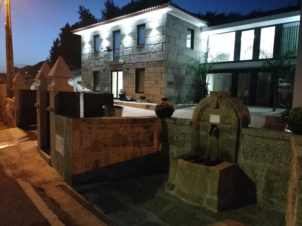 une maison en pierre avec une tombe devant elle dans l'établissement CRASTO PAYVA DOURO NATURE, à Castelo de Paiva
