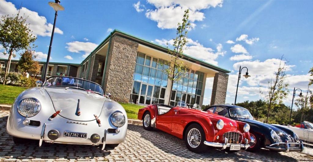 two vintage cars parked in front of a building at Chianti Village Morrocco in Tavarnelle Val di Pesa