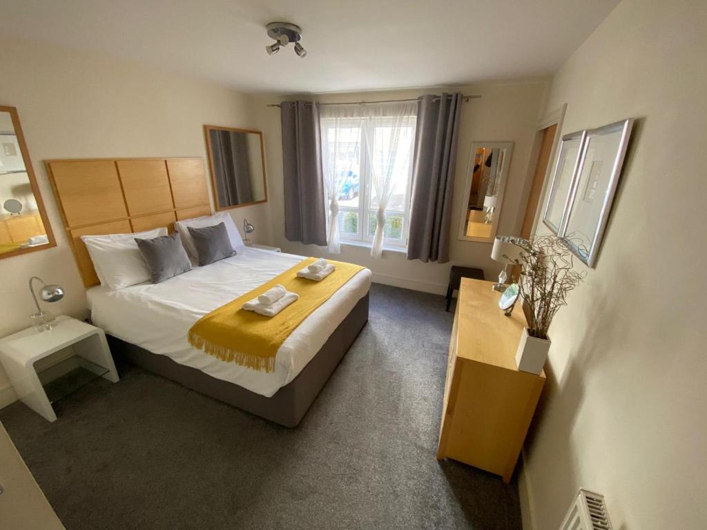 Un dormitorio con una cama grande y una ventana en Hopetoun Apartment with free parking en Edimburgo