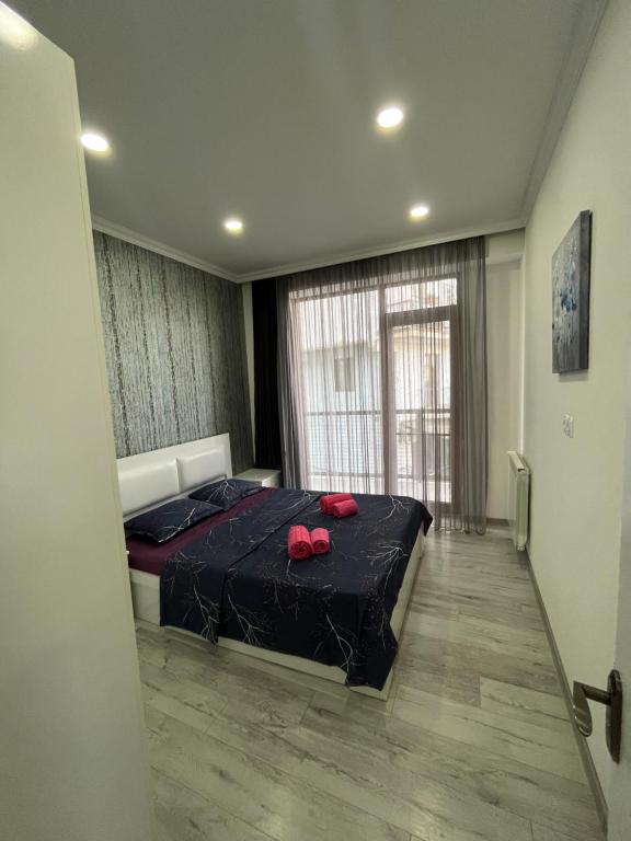 a bedroom with a bed with red slippers on it at Kobi Apartments in Tbilisi City