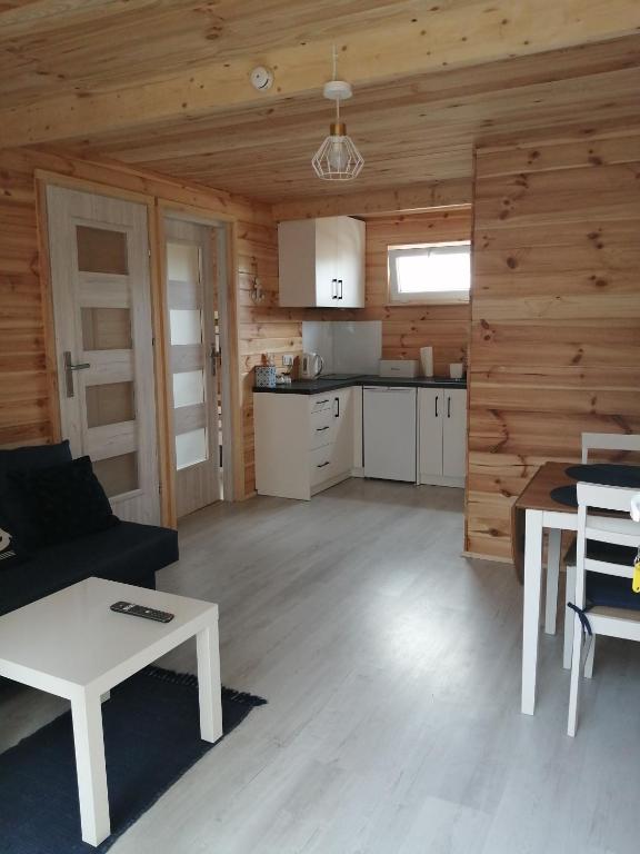 a living room with a couch and a table at Domki w brzozach in Brajniki