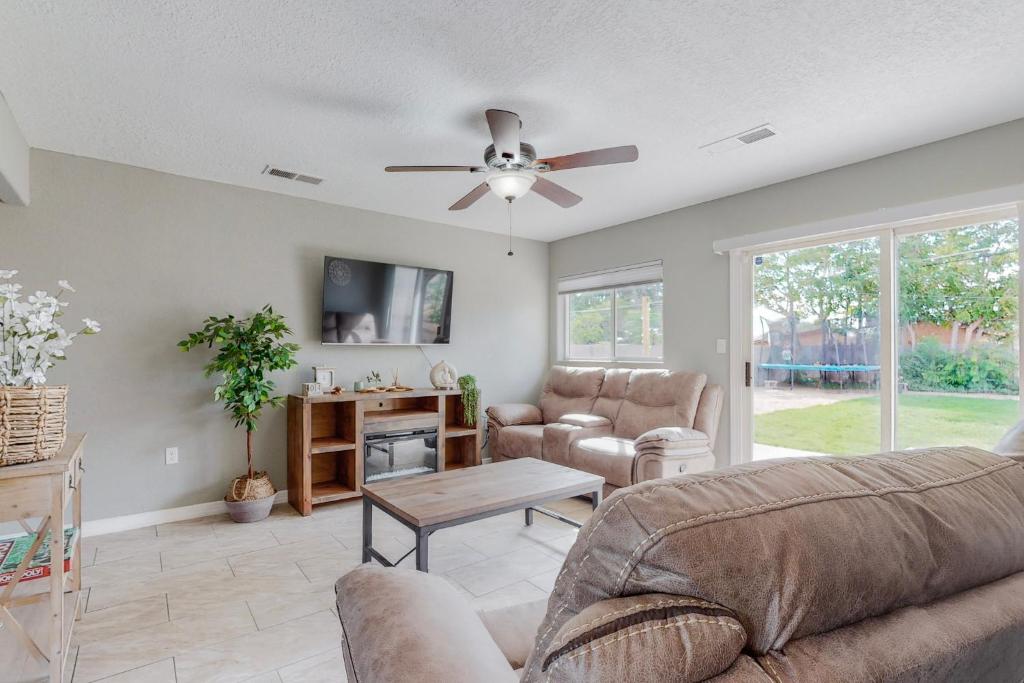 a living room with a couch and a ceiling fan at Comfortable 3-bedroom home with spacious backyard in Albuquerque