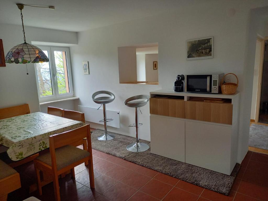 a kitchen with a table and a microwave at Casa di vacanza in Capriasca ( Lugano ) in Bidogno