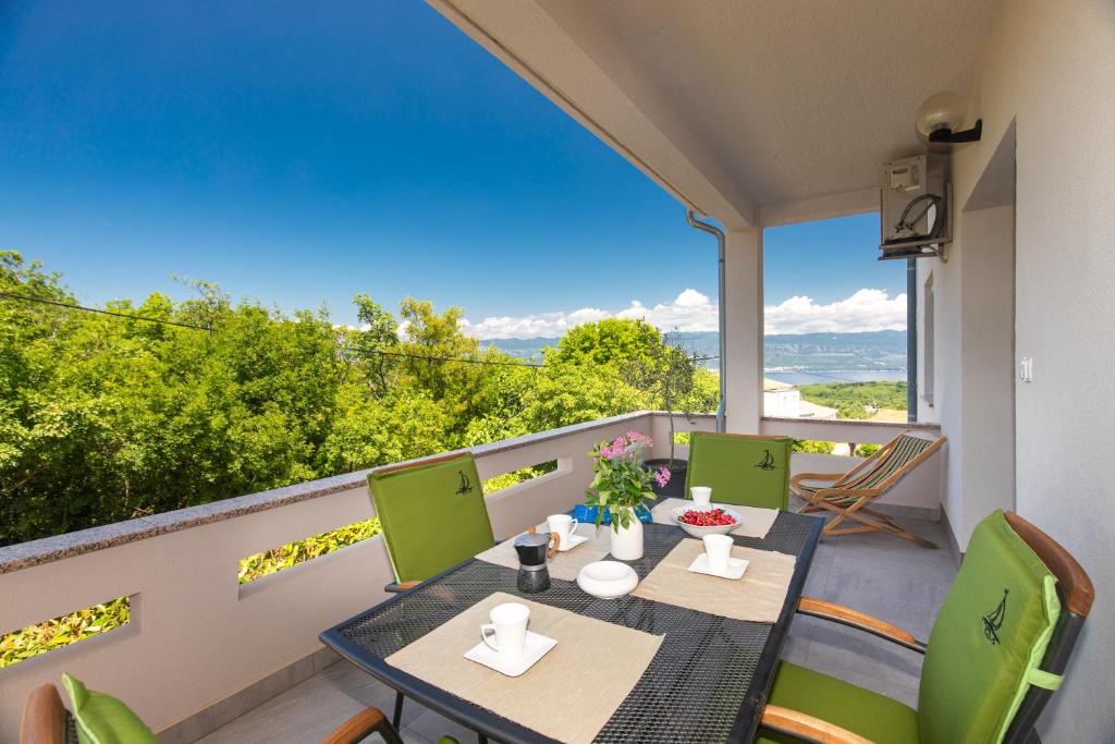 a patio with a table and chairs on a balcony at Apartments House Risika in Risika
