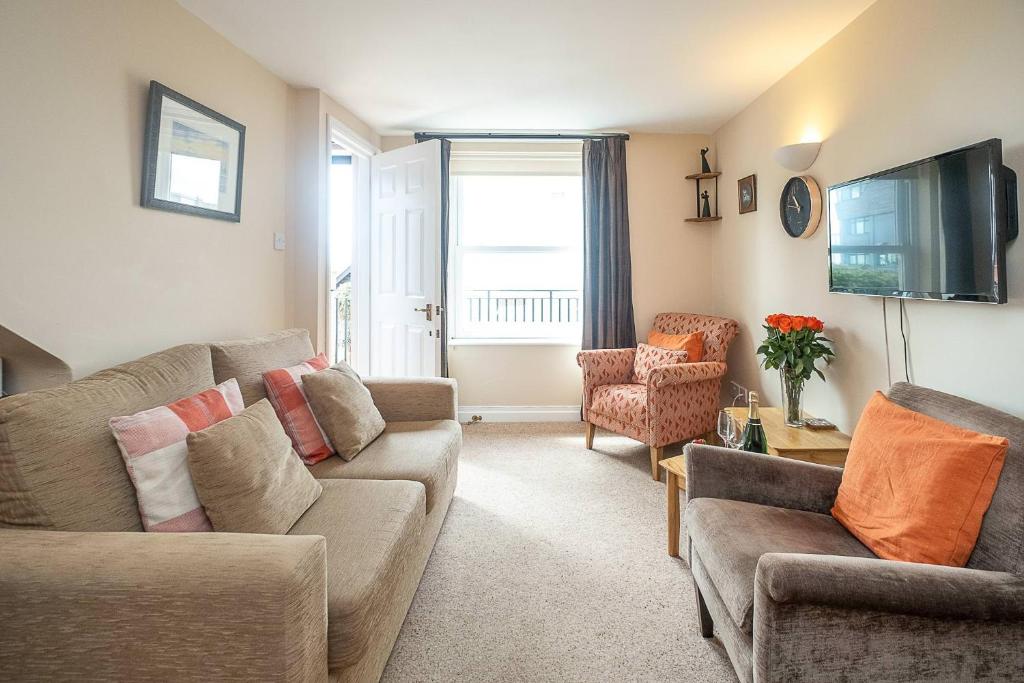 a living room with two couches and a tv at The Haven at Coastguard Court - Aldeburgh Coastal Cottages in Aldeburgh