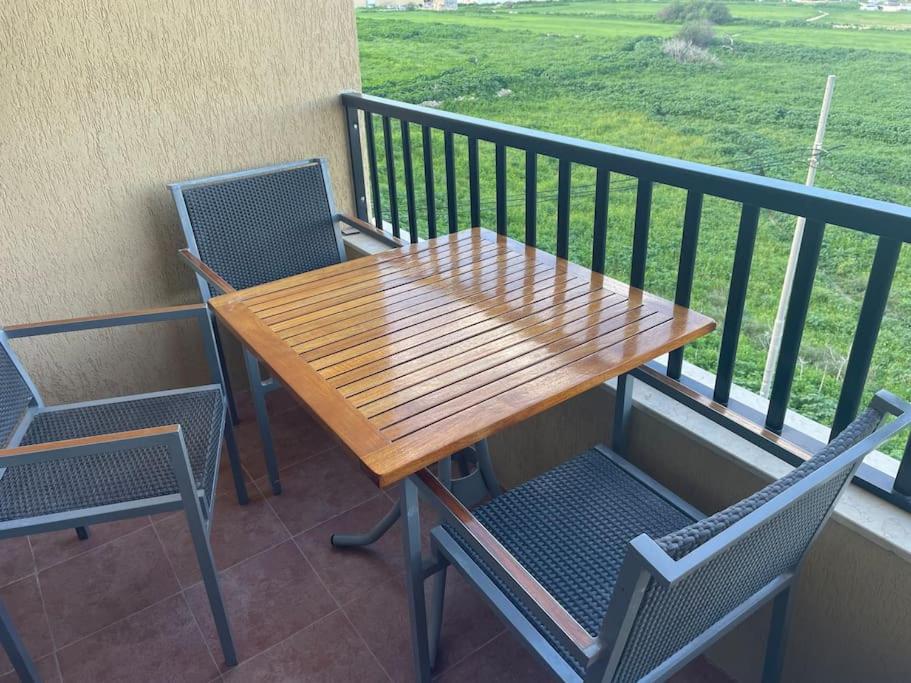 a wooden table and chairs on a balcony at Apartment 5 mins away from the sea in St. Paul's Bay