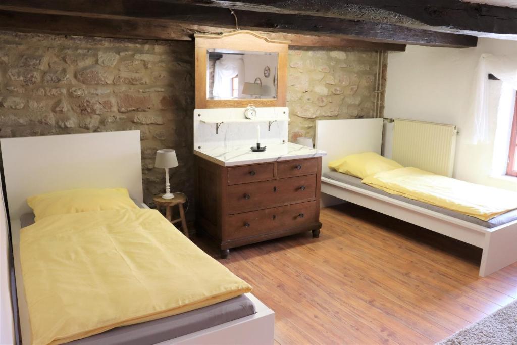 sypialnia z 2 łóżkami, komodą i lustrem w obiekcie Ferienwohnung, Charmantes Bauernhaus, Ferienhaus w mieście Saarlouis