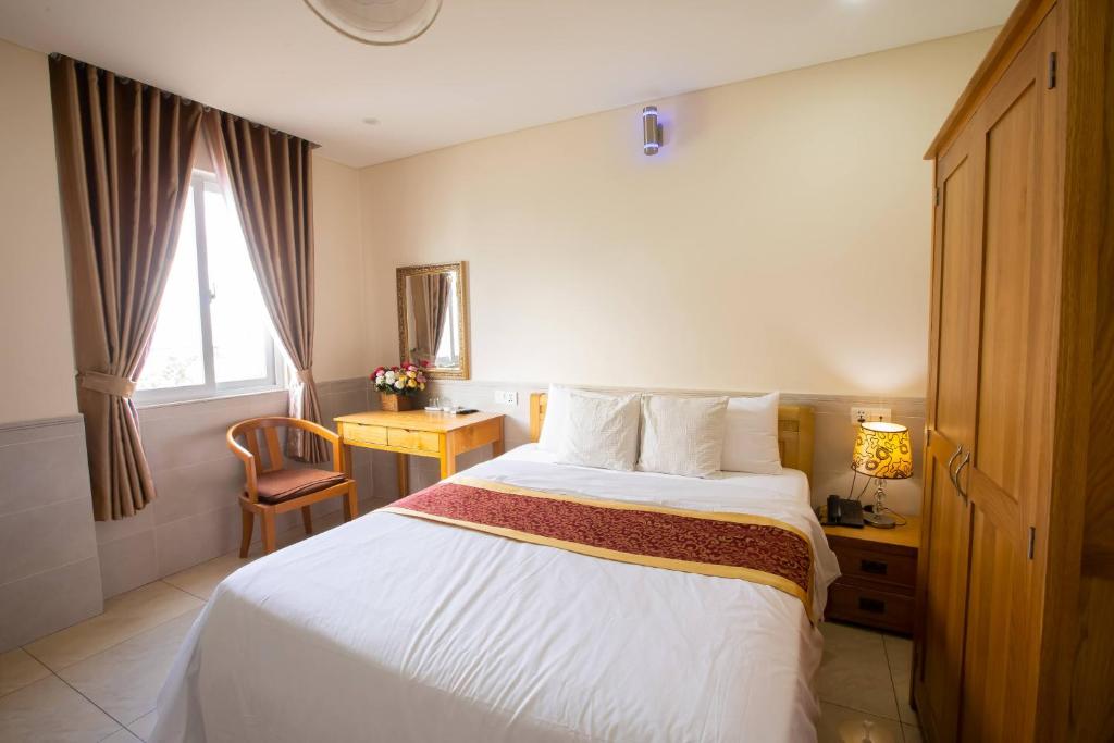 Habitación de hotel con cama y ventana en California Hotel, en Ho Chi Minh