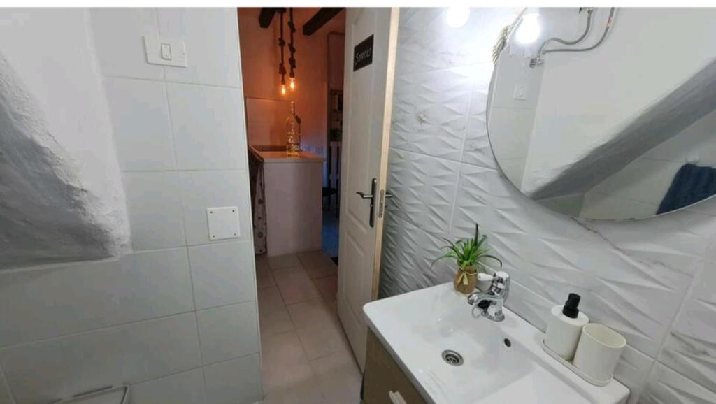 biała łazienka z umywalką i lustrem w obiekcie GRAN CANARIA Oasis La Guancha w mieście Gáldar