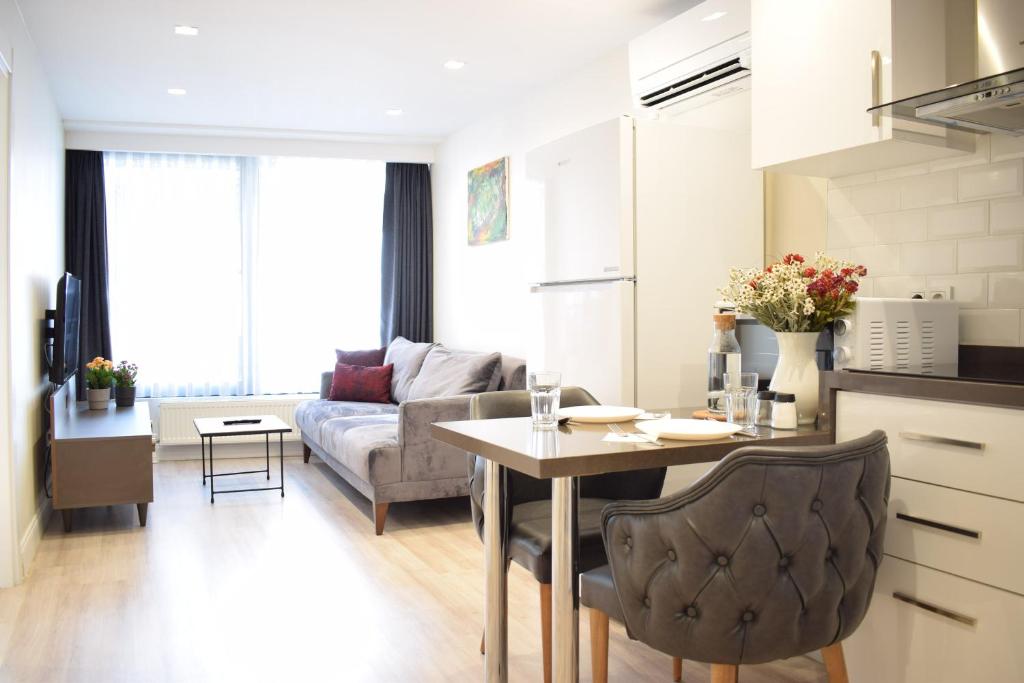 cocina y sala de estar con mesa y sofá en Scope Apartment, en Estambul