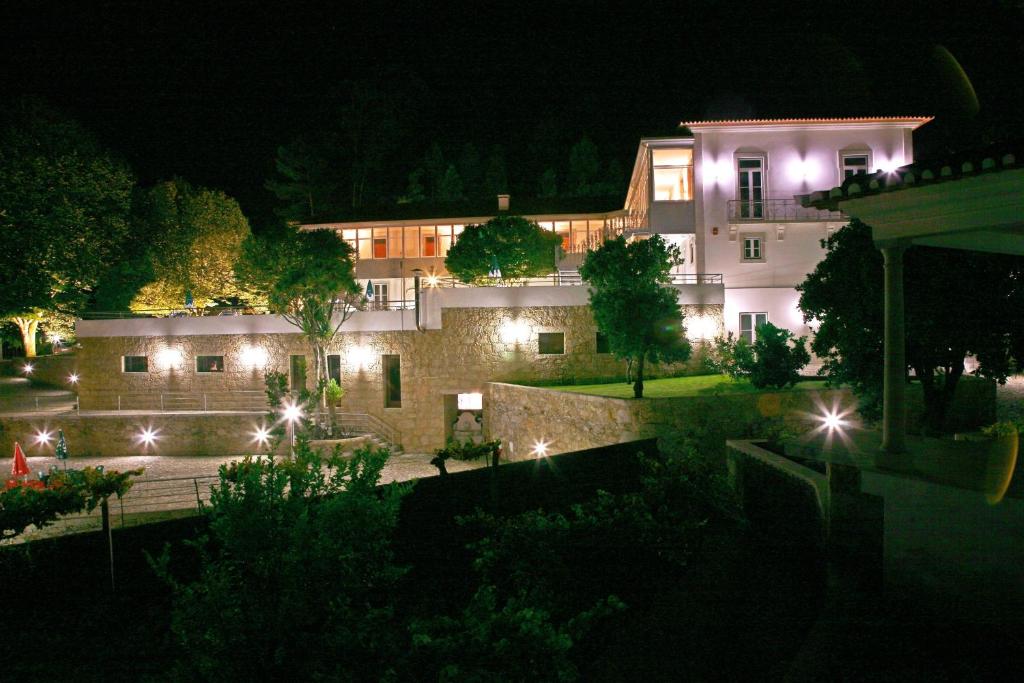 un bâtiment avec des lumières devant lui la nuit dans l'établissement Hotel Quinta Progresso, à Macieira de Cambra