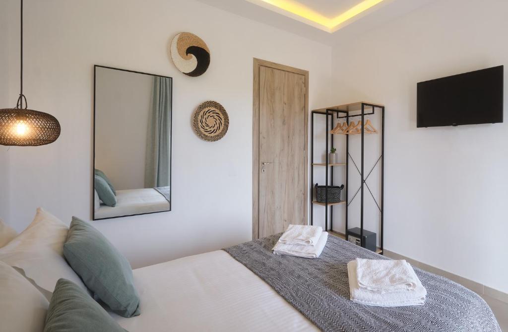 a bedroom with a bed and a tv and mirrors at Heliotopos in Skala Eresou