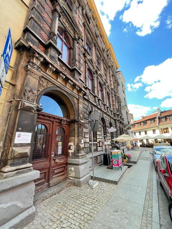 stary budynek z dużymi drewnianymi drzwiami na ulicy w obiekcie Strumykowa 19 - Old Town w Toruniu