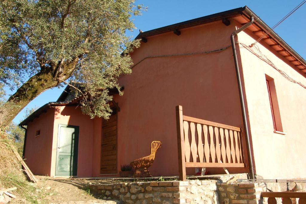 ein Haus mit einer Bank davor in der Unterkunft Azienda Agricola Colle Paradiso in Mompeo