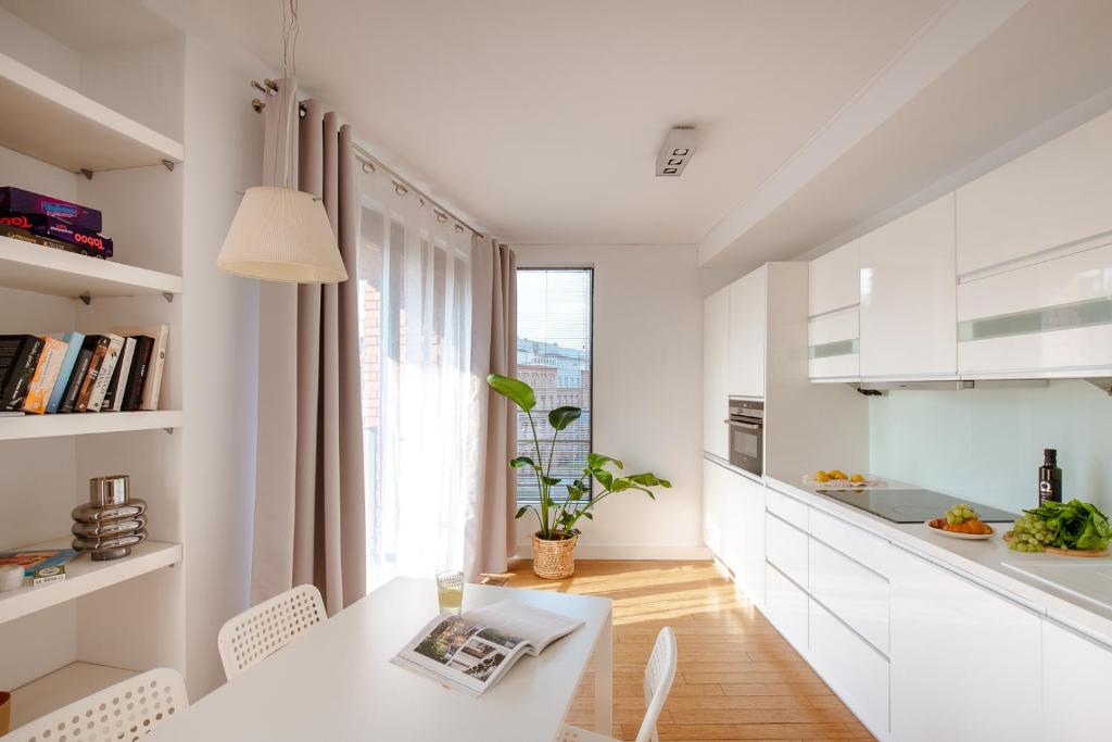 una cucina bianca con tavolo, sedie e finestra di Spacious apartment close to Main Station / Galeria Krakowska a Cracovia