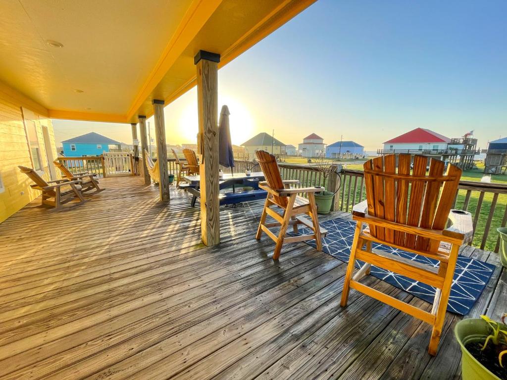 Un porche con sillas y vista al mar. en Laidback, Spacious Luxury with Hot Tub, Fully Stocked and Private Beach Access, en Bolivar Peninsula