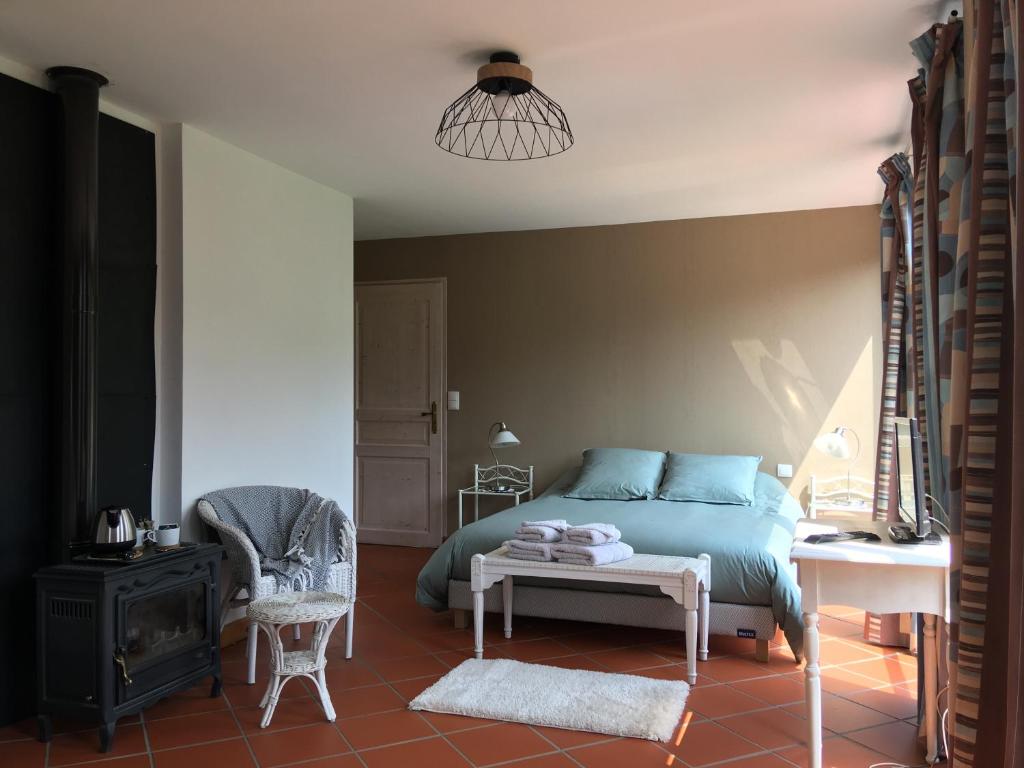a bedroom with a bed and a chair and a table at Chambres d'hôtes Mas La Tardosse in Prats-de-Mollo-la-Preste