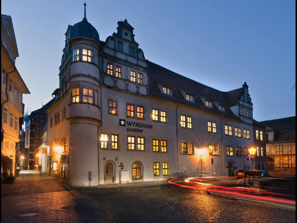 ein großes Gebäude in der Nacht auf einer Straße in der Unterkunft Wyndham Garden Quedlinburg Stadtschloss in Quedlinburg