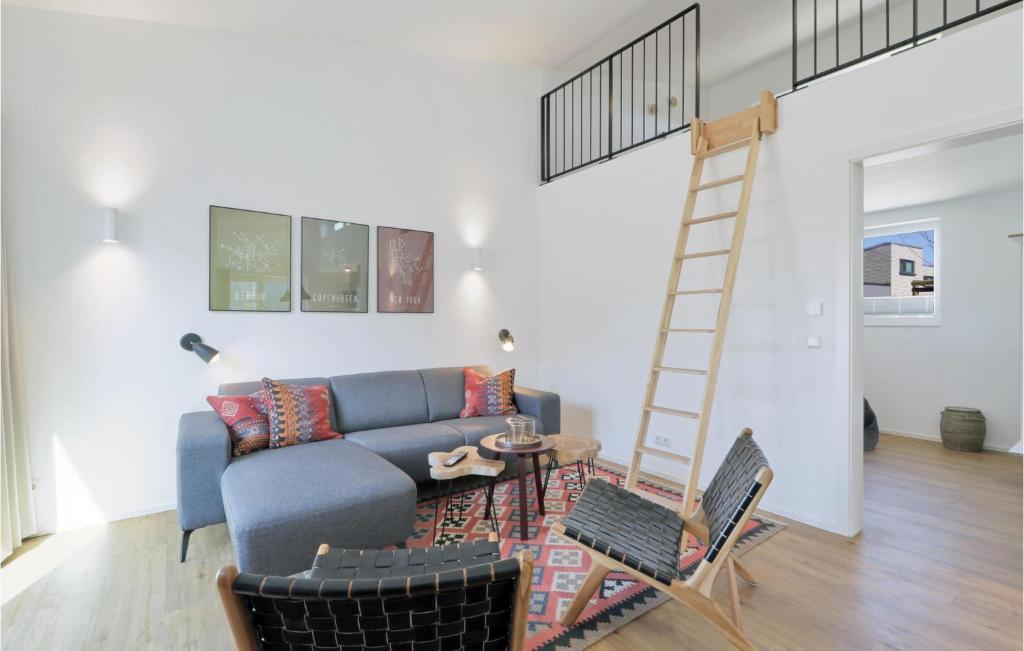 ein Wohnzimmer mit einem blauen Sofa und einer Leiter in der Unterkunft Awesome Home In Lembruch-dmmer See With Kitchen in Lembruch