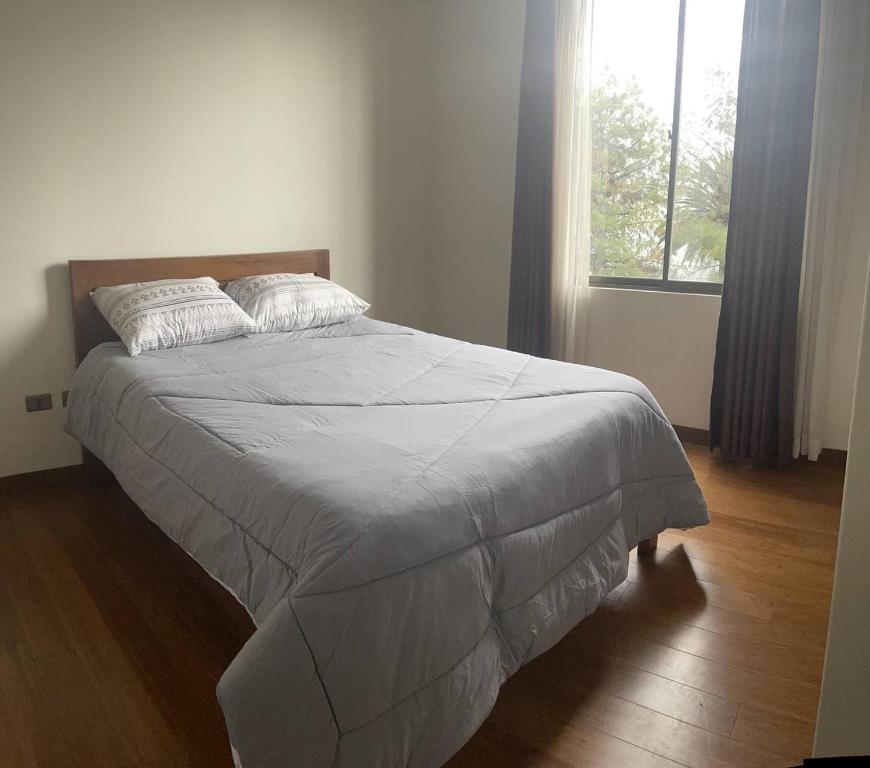 a large bed in a bedroom with a window at Lujoso depto. en ”Torre Nur” in Cochabamba