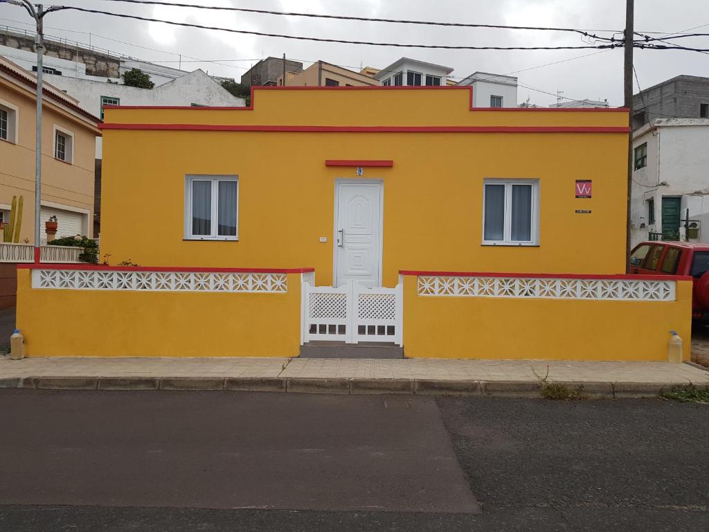 a yellow house with a white door on a street at Vv CASA JULIA in Valverde