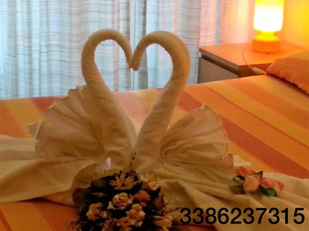 サレルノにあるAmarfia Bed & Breakfast - Your Home In Salernoのベッドの上に置いた白鳥
