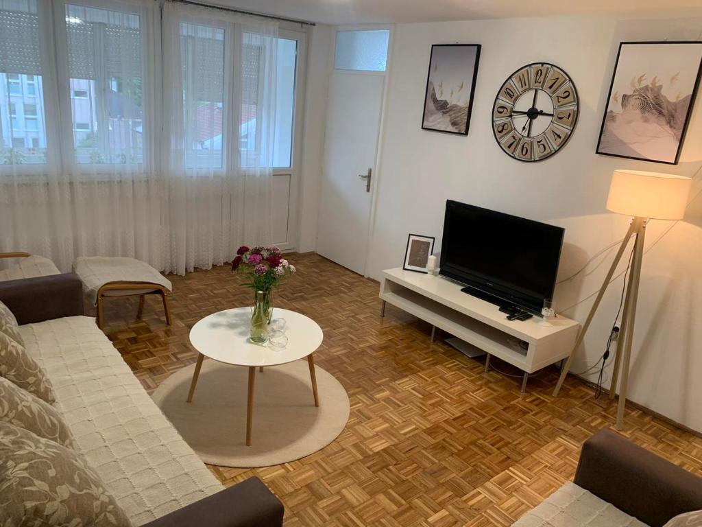 uma sala de estar com um sofá, uma televisão e uma mesa em Apartman Nova Varos em Banja Luka