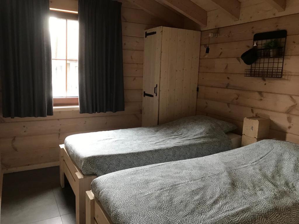 duas camas de solteiro em um quarto com janela em Chalet Momage dichtbij Skiliften, Skiverhuur en Bikepark! em Winterberg