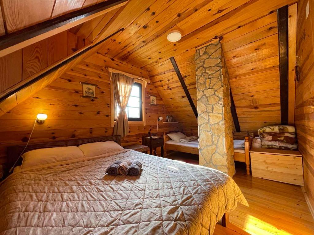 a bedroom with a bed in a wooden cabin at Brvnare Na Brdu in Šljivovica