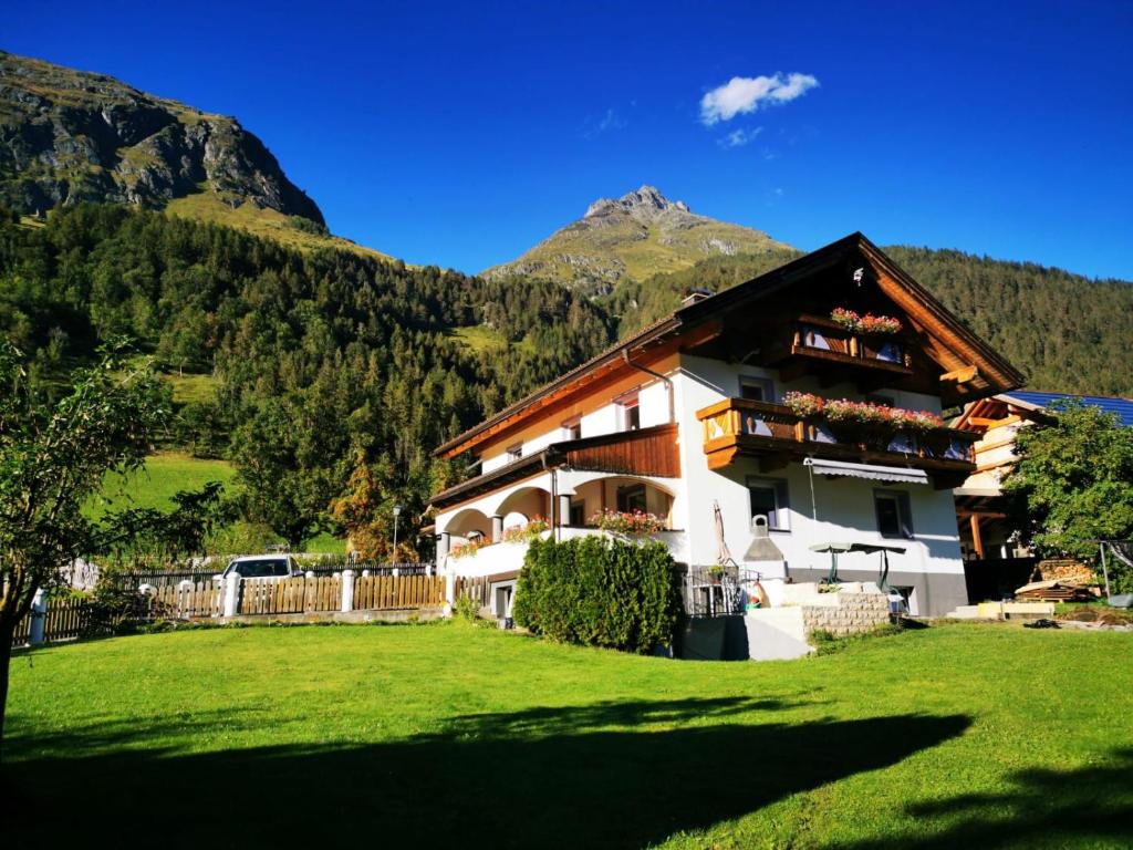 a house in the mountains with a green yard at Appartment Elias in Bichl