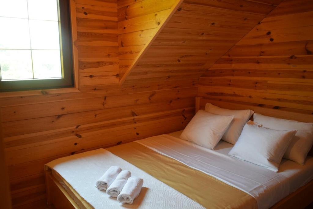 Vila Bridge Tara في بليفليا: سرير في غرفة خشبية مع وسادتين