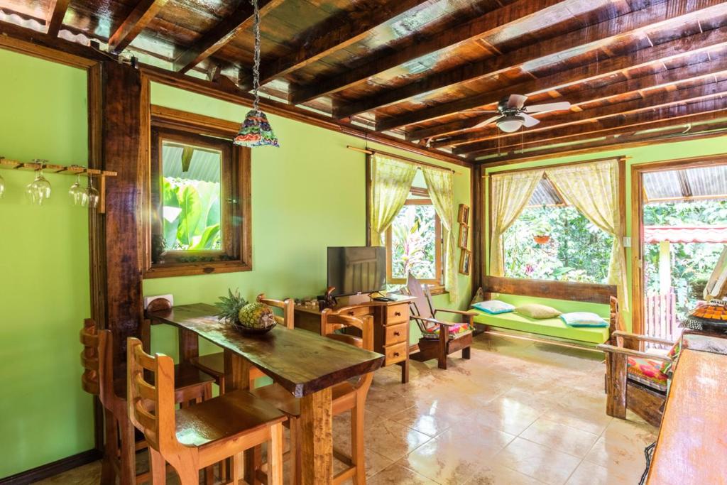 uma sala de estar com uma mesa e cadeiras e um sofá em casa chilamates em Tortuguero