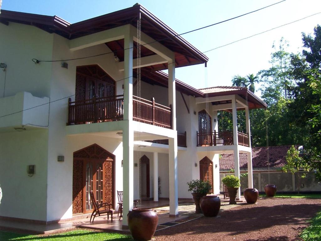 Cette grande maison blanche dispose d'un balcon. dans l'établissement Villa Wunderschön, à Bentota