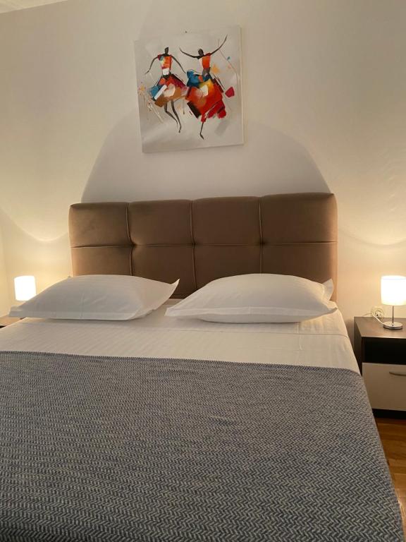 - une chambre avec un lit orné d'une peinture murale dans l'établissement Apartmani Silence, à Rogoznica