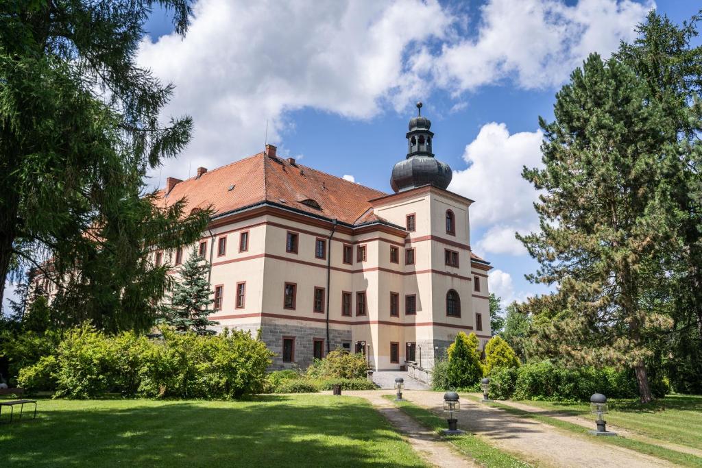 duży budynek z wieżą na górze w obiekcie Zámek Lnáře w mieście Lnáře