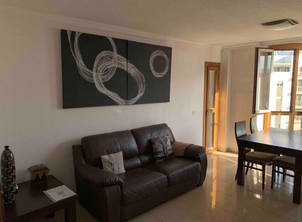 sala de estar con sofá marrón y mesa en Apartamento Atlantida, en Santa Cruz de Tenerife