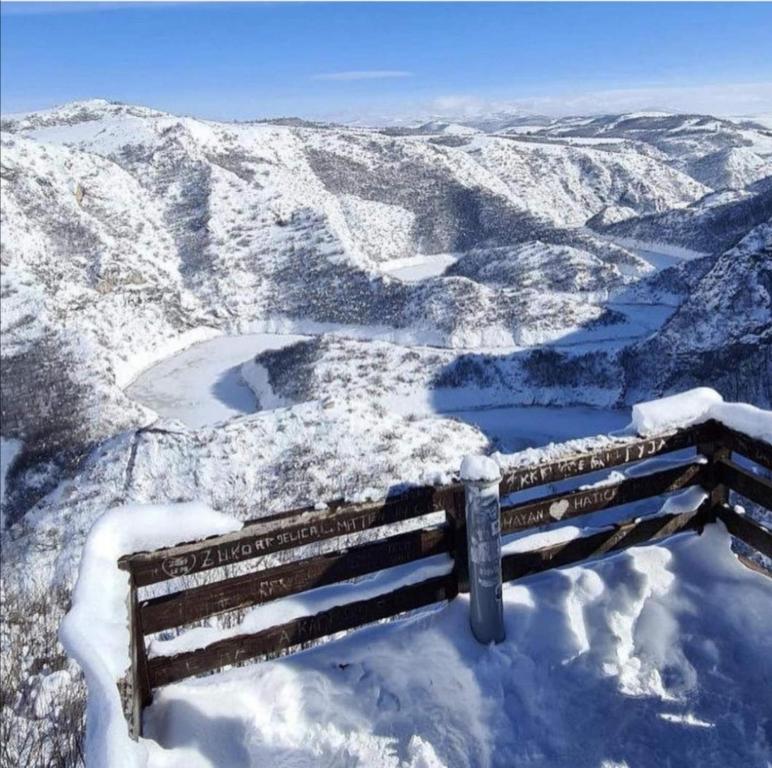 a bench sitting on top of a snow covered mountain at Apartman Petar in Nova Varoš