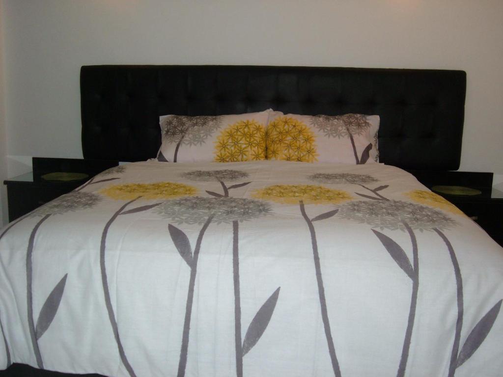 ein Bett mit zwei gelben Blumen darüber in der Unterkunft The Place Apartments in Amman