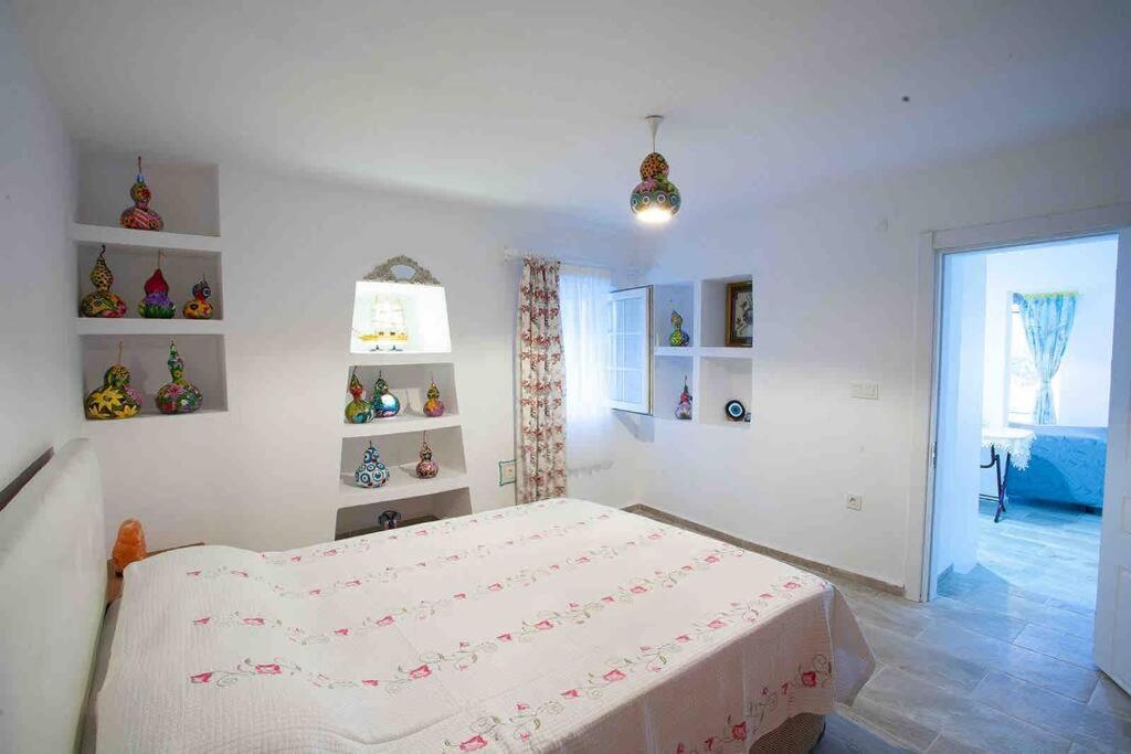 a white bedroom with a bed and a window at Mor Salkım Evi in Datca