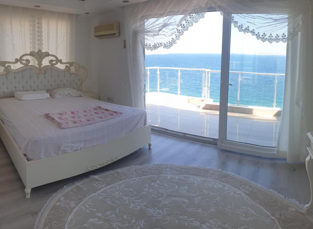 a bedroom with a bed and a balcony with the ocean at Antalya Konyaaltında muhteşem GEMİ EV in Antalya