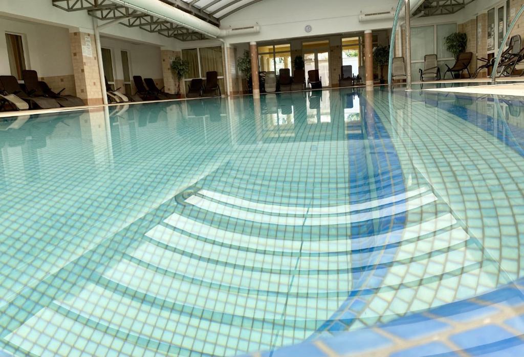 - une piscine revêtue de carrelage bleu et blanc dans l'établissement AquaLITA Apartman Zalakaros, à Zalakaros