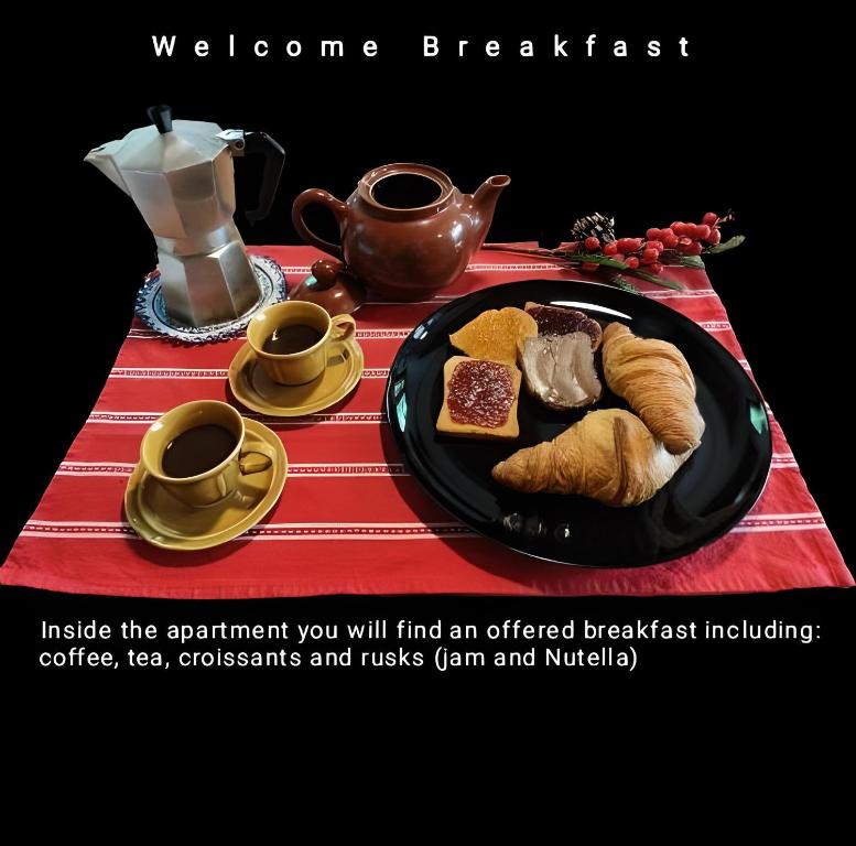 une table avec une assiette de nourriture et des tasses de café dans l'établissement Accogliente chalet in mansarda, à Courmayeur