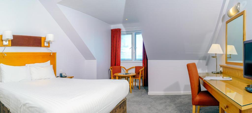 a hotel room with a bed and a desk at Portrush Atlantic Hotel in Portrush