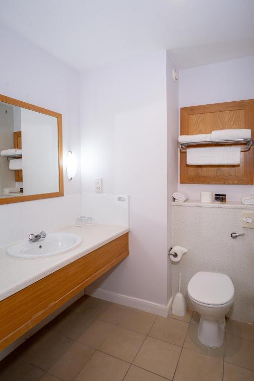 a bathroom with a sink and a toilet and a mirror at Portrush Atlantic Hotel in Portrush