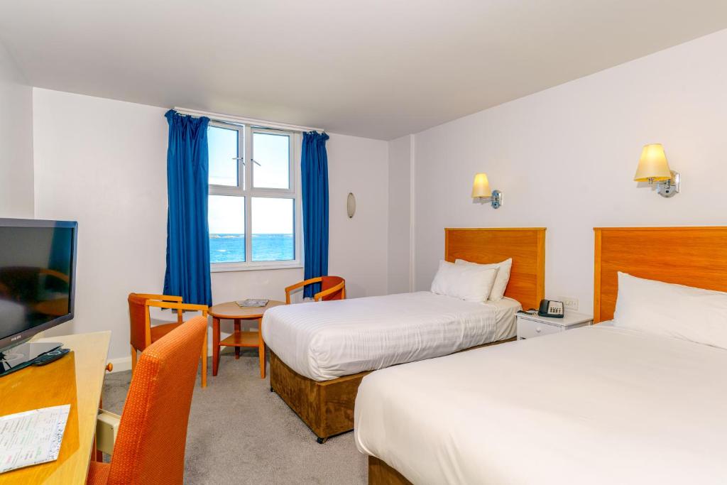 a hotel room with two beds and a television at Portrush Atlantic Hotel in Portrush