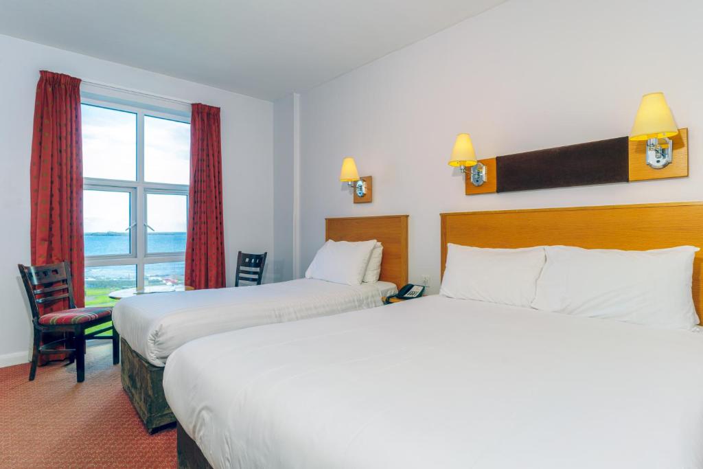 a hotel room with two beds and a window at Portrush Atlantic Hotel in Portrush