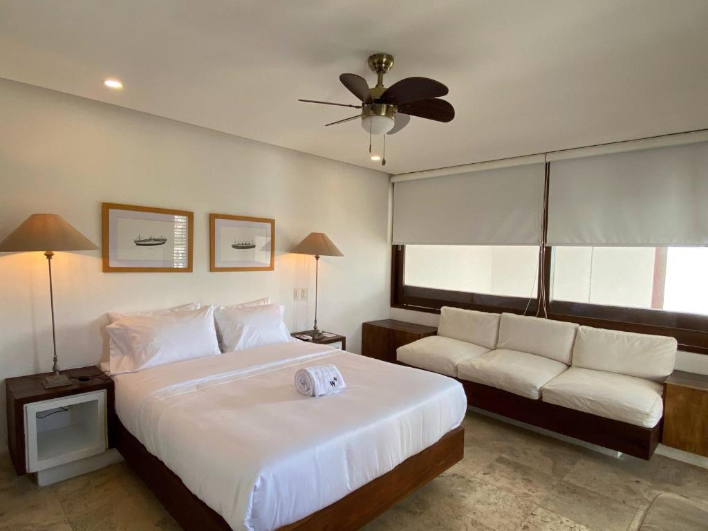 um quarto com uma grande cama branca e um sofá em Sophisticated 4BR House with Pool in Cartagena em Cartagena das Índias