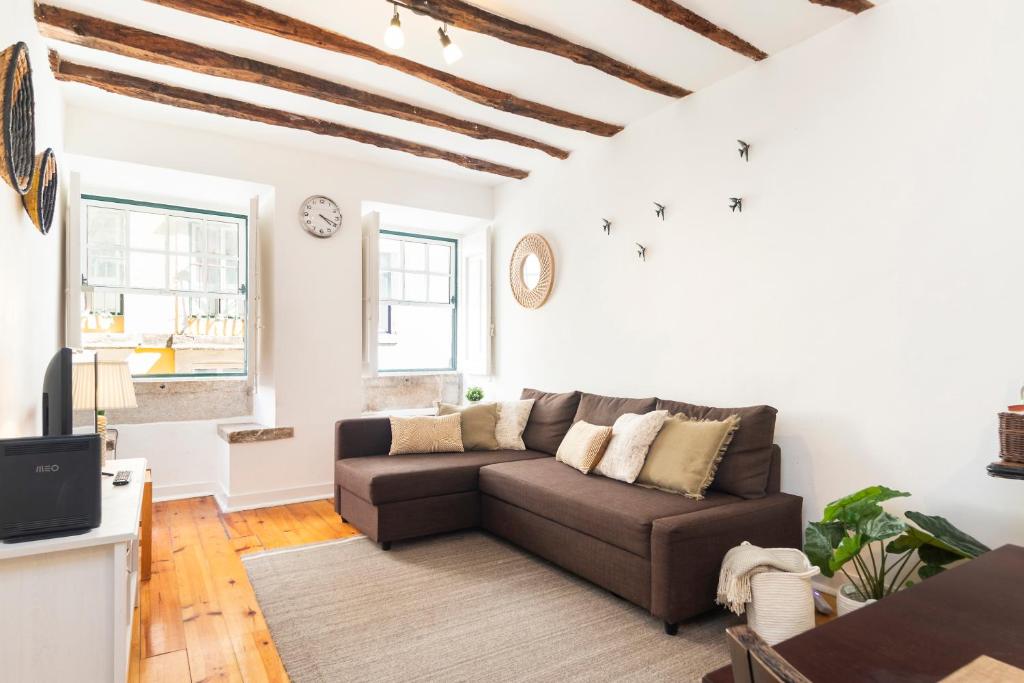 a living room with a couch and a tv at Alfama Patio Apartments in Lisbon