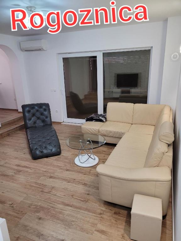 a living room with a couch and a chair at Apartament Maja in Rogoznica